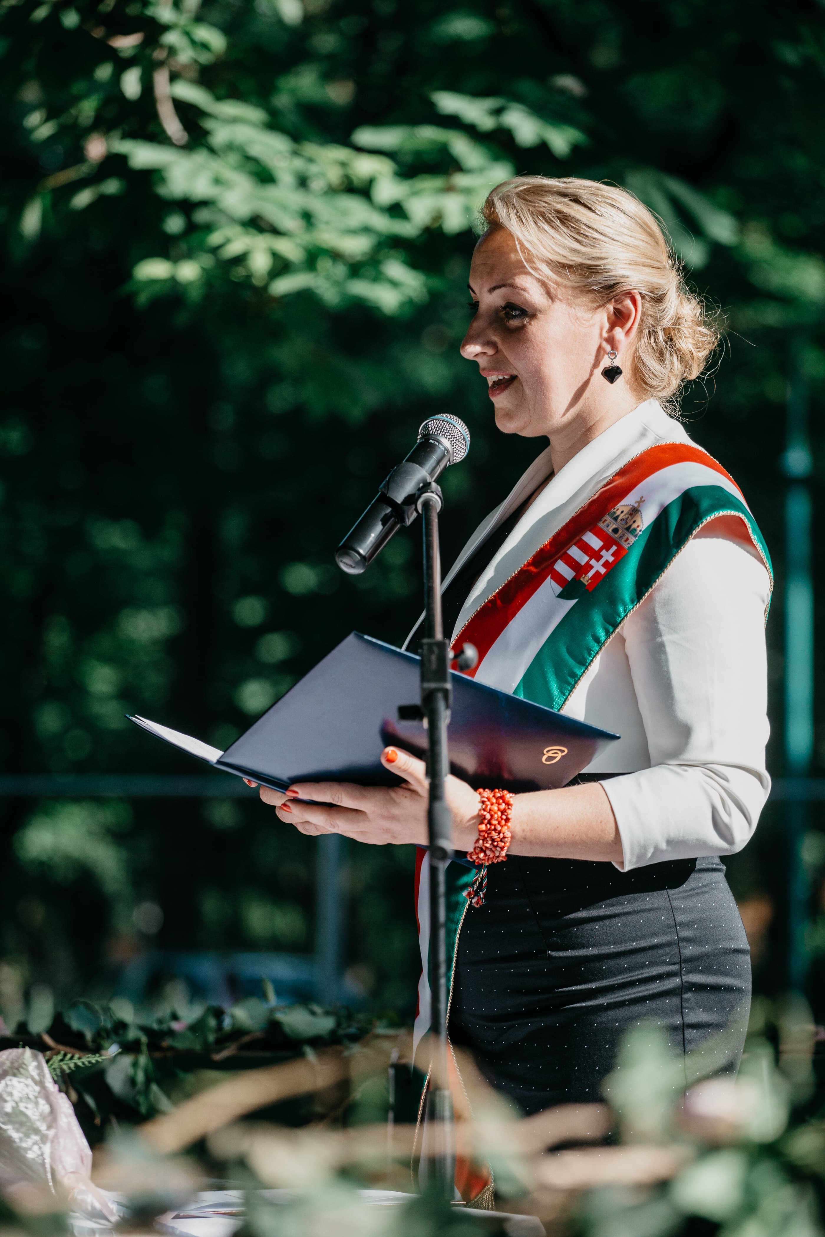 Benkő Angéla szertartást vezet a mikrofon előtt